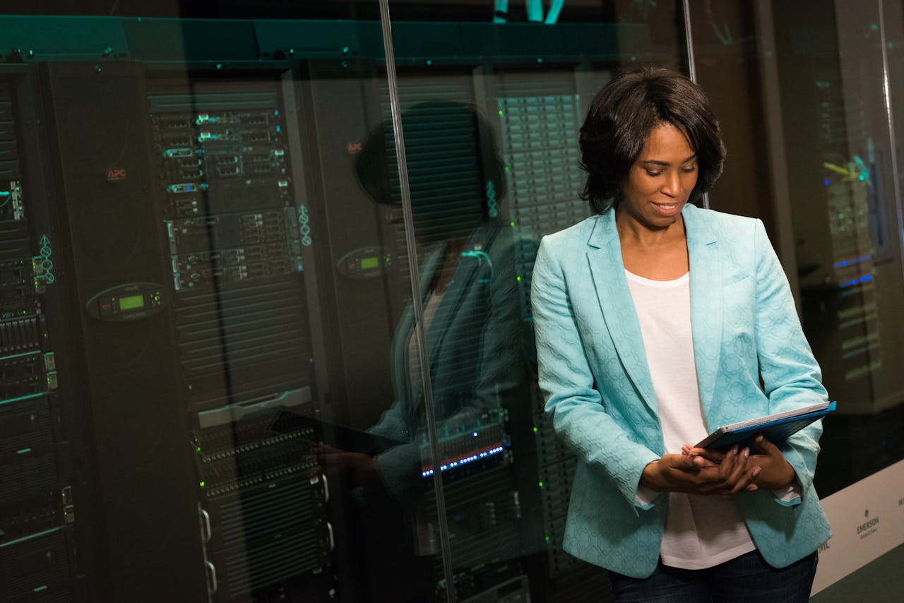 Services Female IT professional examining data servers in a modern data center setting.